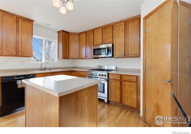 kitchen featuring sink, a center island, light wood-type flooring, and appliances with stainless steel finishes