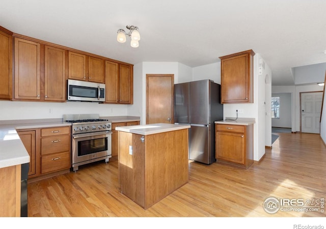 kitchen featuring appliances with stainless steel finishes, light hardwood / wood-style floors, and a kitchen island