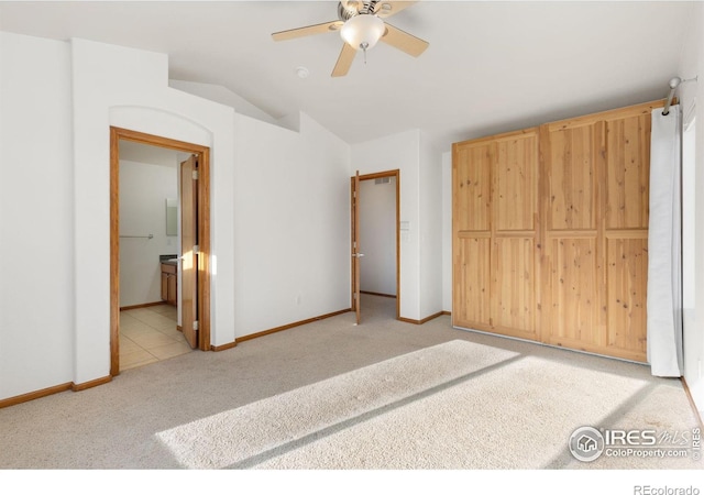 unfurnished bedroom featuring a closet, ensuite bathroom, ceiling fan, and light colored carpet