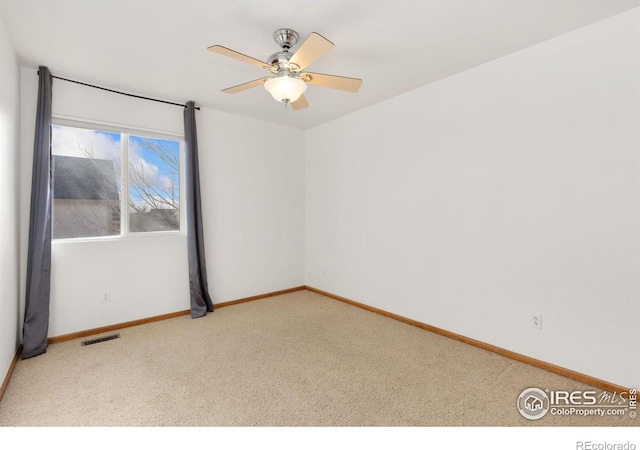 carpeted spare room with ceiling fan