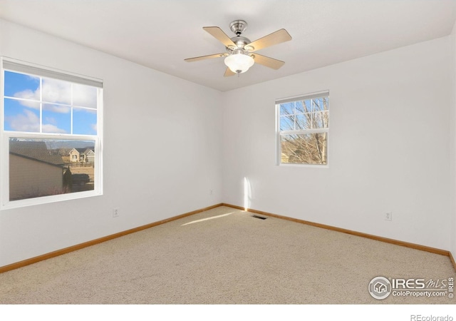 spare room featuring carpet and ceiling fan