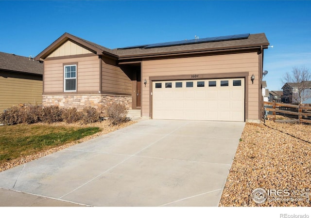 ranch-style house with solar panels and a garage