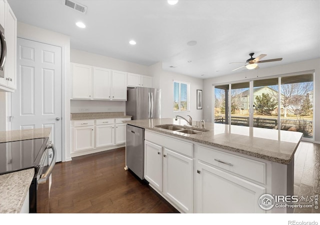 kitchen featuring stainless steel appliances, a kitchen island with sink, dark wood-type flooring, sink, and white cabinetry