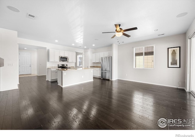 unfurnished living room with ceiling fan and dark hardwood / wood-style flooring