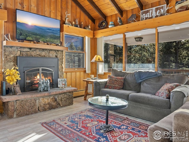 living room with lofted ceiling with beams, light hardwood / wood-style floors, wooden ceiling, and a fireplace