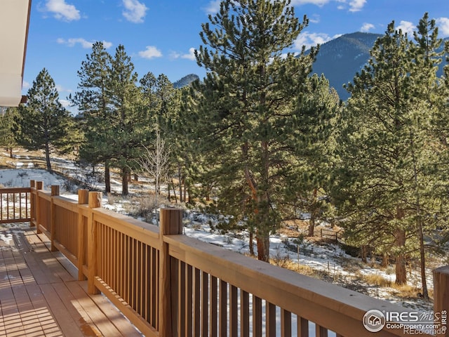 snow covered deck with a mountain view