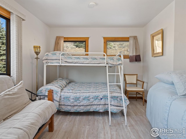 bedroom with light hardwood / wood-style floors and multiple windows