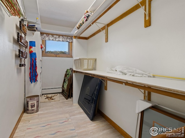 washroom featuring light wood-type flooring and a baseboard heating unit