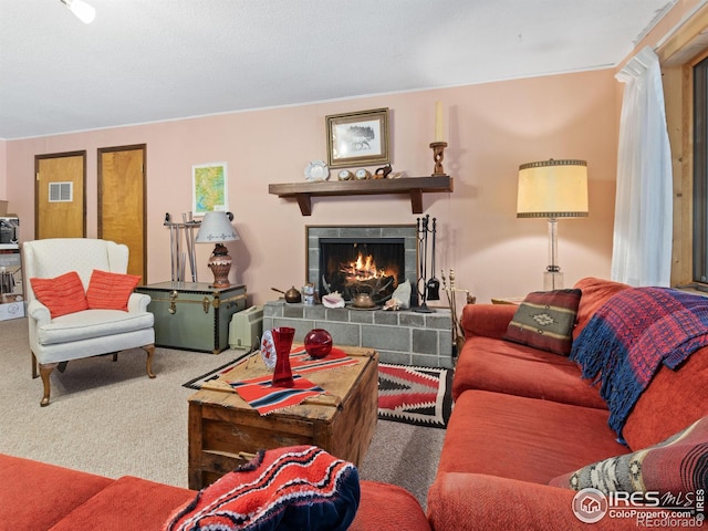 carpeted living room featuring a tile fireplace