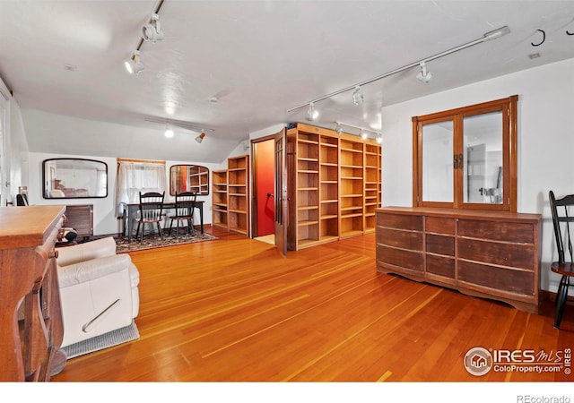 interior space with hardwood / wood-style floors and rail lighting