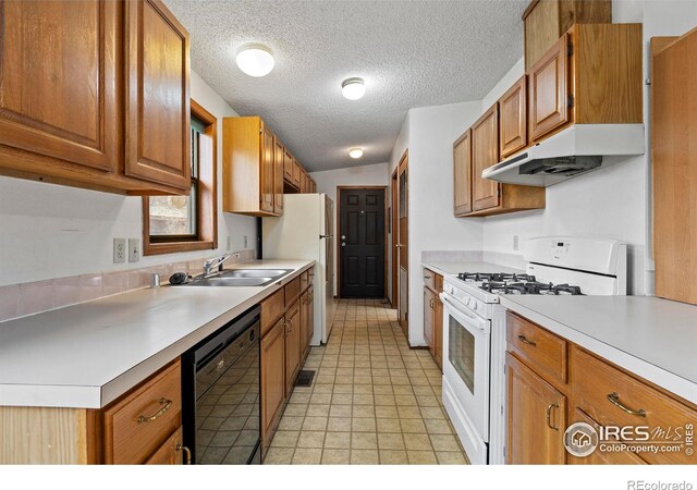 kitchen with a textured ceiling, white appliances, sink, and vaulted ceiling