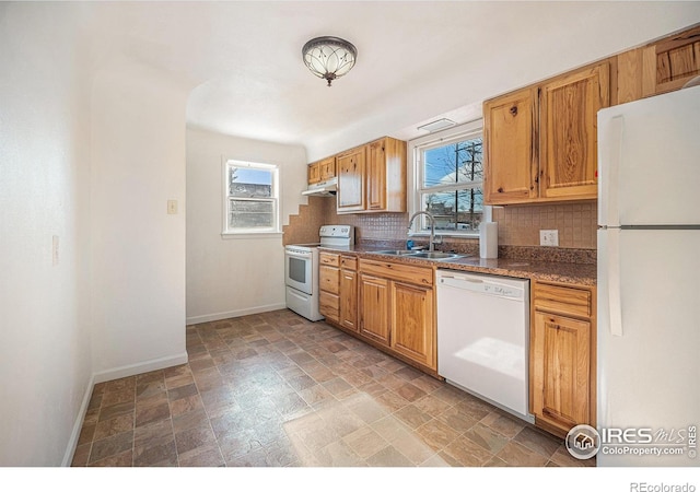 kitchen featuring decorative backsplash, sink, a healthy amount of sunlight, and white appliances