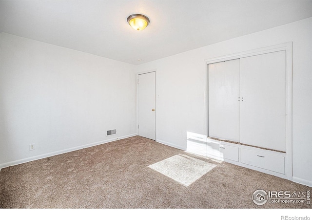 unfurnished bedroom featuring carpet floors and a closet