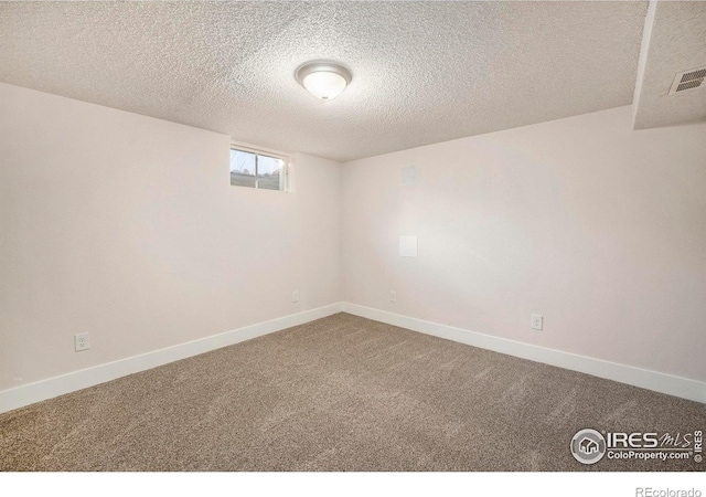 carpeted empty room with a textured ceiling