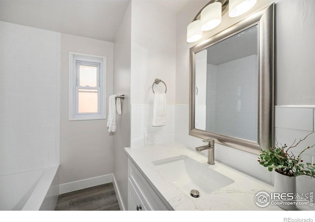 bathroom with vanity, wood-type flooring, and a washtub