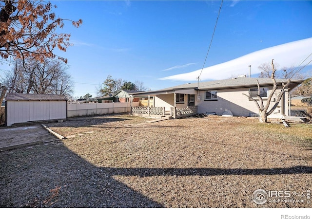 rear view of house featuring a storage unit