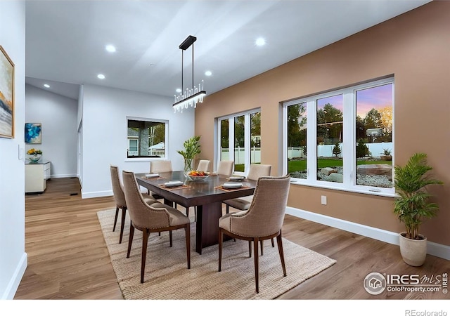 dining space featuring light wood-type flooring and a notable chandelier