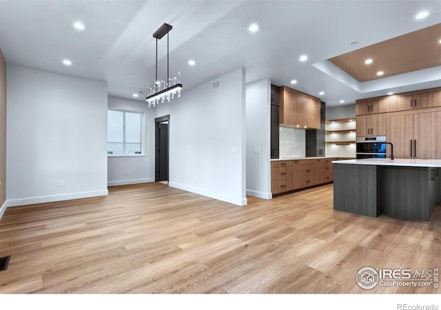 kitchen with decorative light fixtures and light wood-type flooring