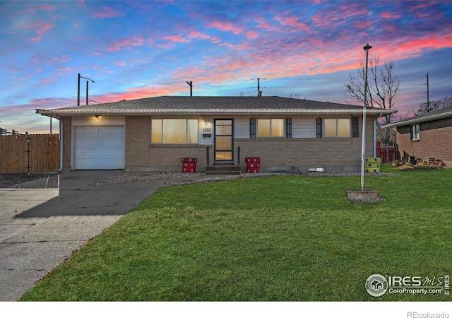 ranch-style home with a yard and a garage