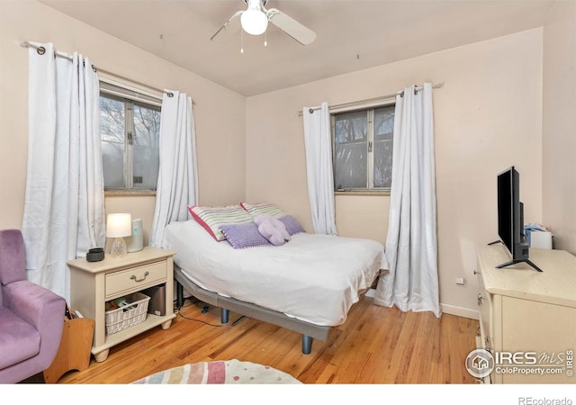 bedroom with ceiling fan and light wood-type flooring