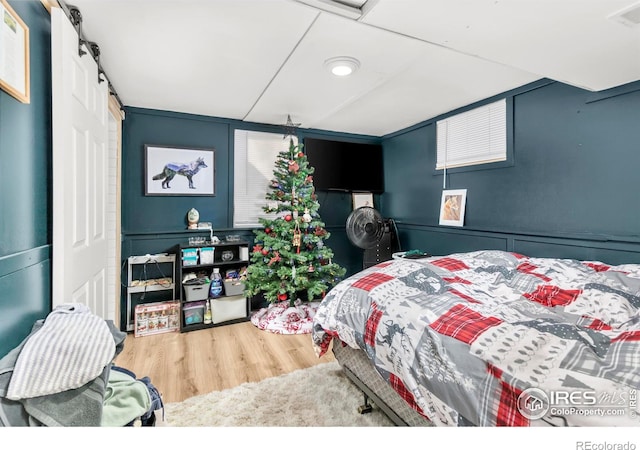 bedroom featuring hardwood / wood-style floors and a barn door