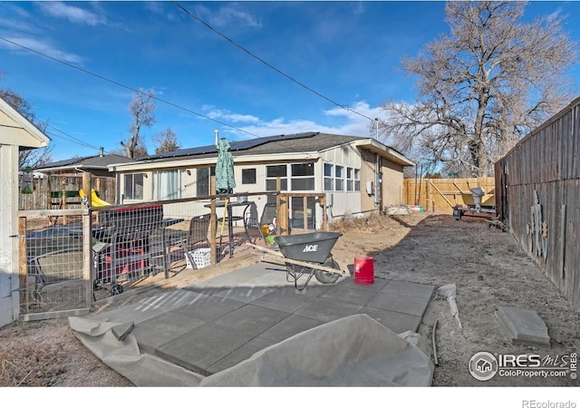 rear view of house featuring a patio area and solar panels