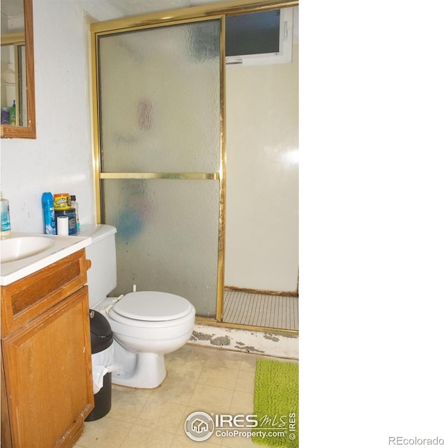 bathroom with tile patterned flooring, vanity, toilet, and walk in shower