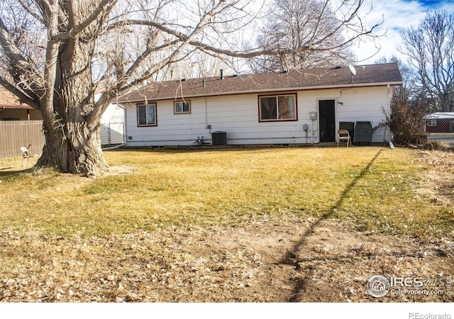 back of property with a lawn and central AC unit