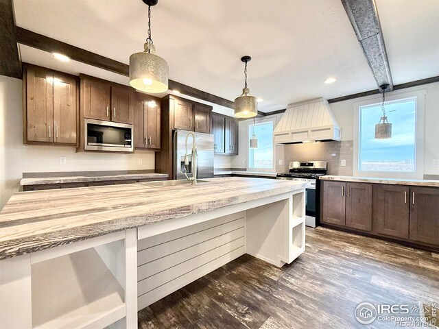 kitchen with beamed ceiling, a healthy amount of sunlight, dark hardwood / wood-style flooring, custom range hood, and stainless steel appliances