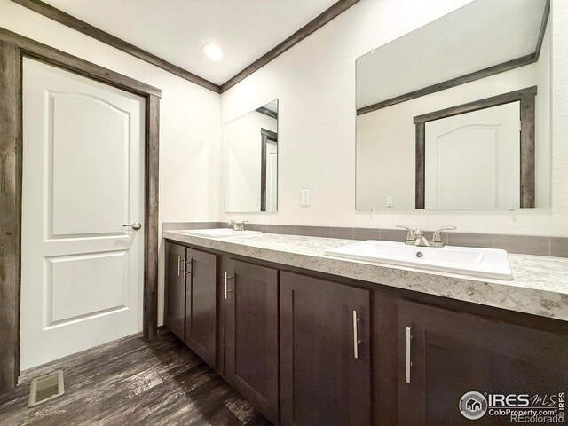 bathroom featuring hardwood / wood-style floors, vanity, and crown molding