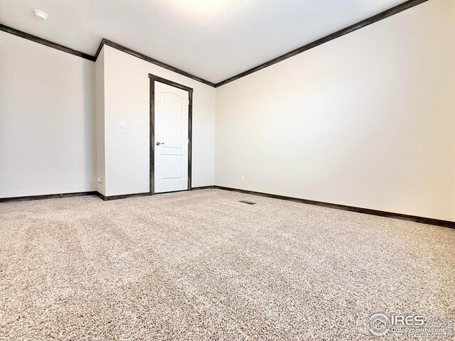 unfurnished room featuring carpet flooring, lofted ceiling, and ornamental molding