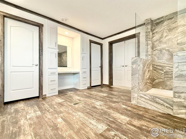 unfurnished bedroom with crown molding and wood-type flooring