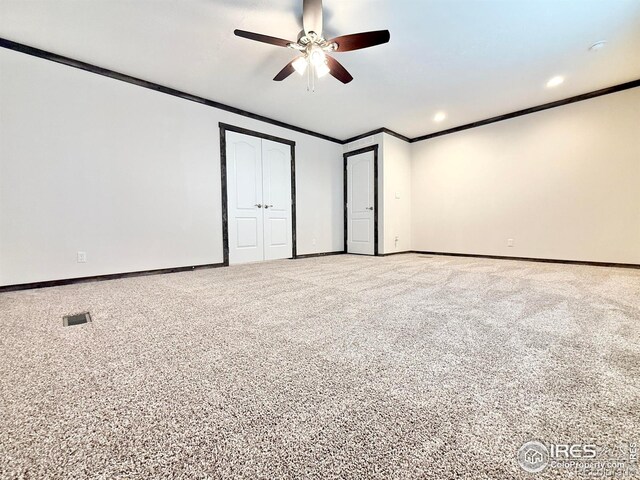 unfurnished bedroom featuring ceiling fan, crown molding, and carpet floors