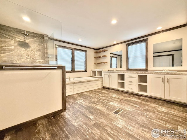 kitchen featuring hardwood / wood-style floors, crown molding, sink, hanging light fixtures, and white cabinetry