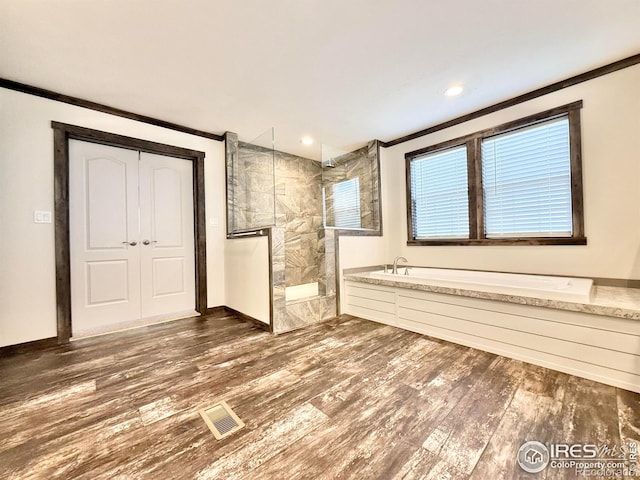 bathroom featuring ornamental molding, independent shower and bath, and hardwood / wood-style flooring