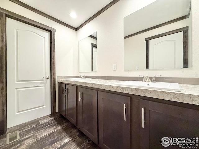 bathroom featuring hardwood / wood-style floors, vanity, and ornamental molding