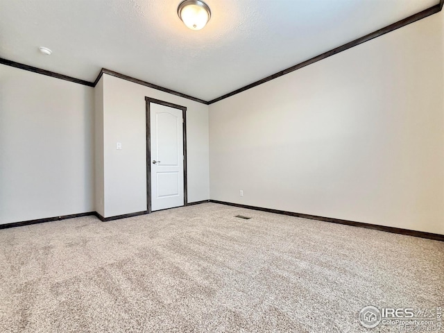 carpeted empty room with a textured ceiling and crown molding