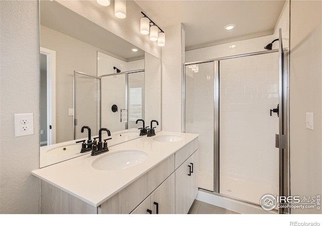 bathroom featuring tile patterned flooring, vanity, and walk in shower