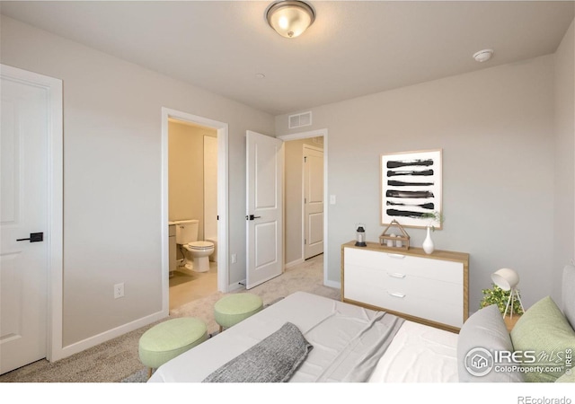 bedroom featuring light carpet and ensuite bathroom