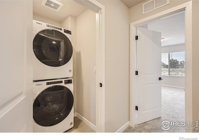 washroom featuring light colored carpet and stacked washer and clothes dryer