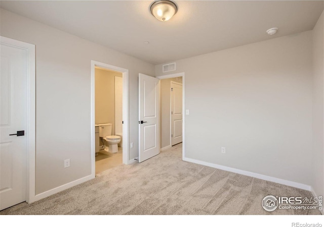 unfurnished bedroom with ensuite bathroom and light colored carpet