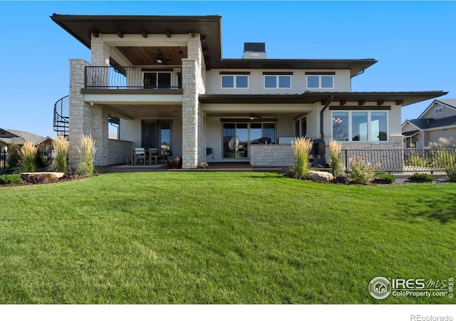 rear view of house featuring a lawn, ceiling fan, a patio area, and a balcony