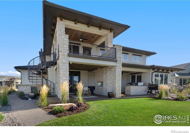 modern home with a front yard, ceiling fan, a balcony, exterior kitchen, and a patio