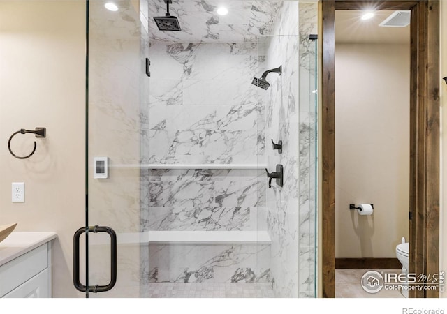 bathroom with walk in shower, vanity, and toilet