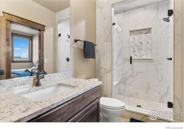 bathroom with vanity, toilet, and a shower with shower door