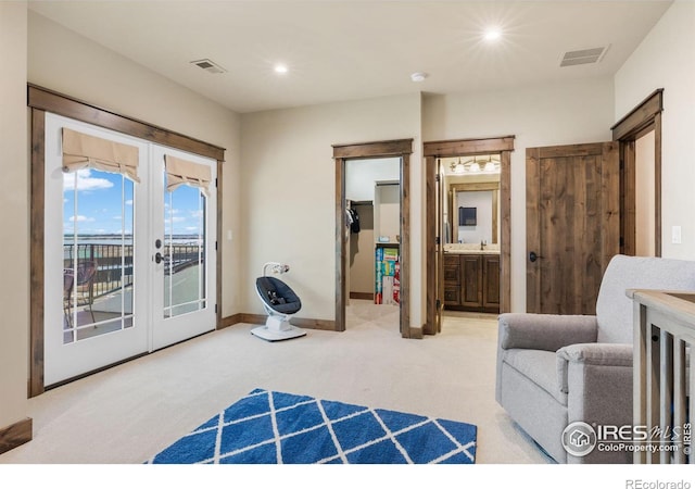 carpeted bedroom featuring access to exterior, ensuite bathroom, and french doors