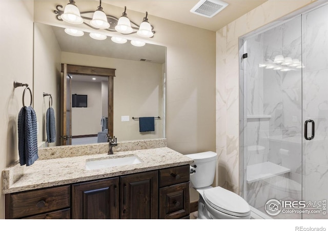 bathroom with vanity, a shower with shower door, and toilet