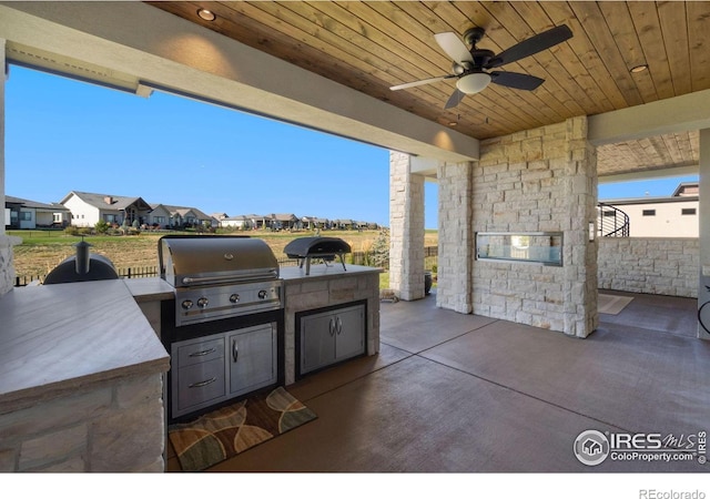 view of patio / terrace with area for grilling, ceiling fan, and exterior kitchen