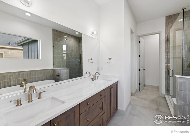 full bath featuring double vanity, a sink, a bathing tub, and a shower stall