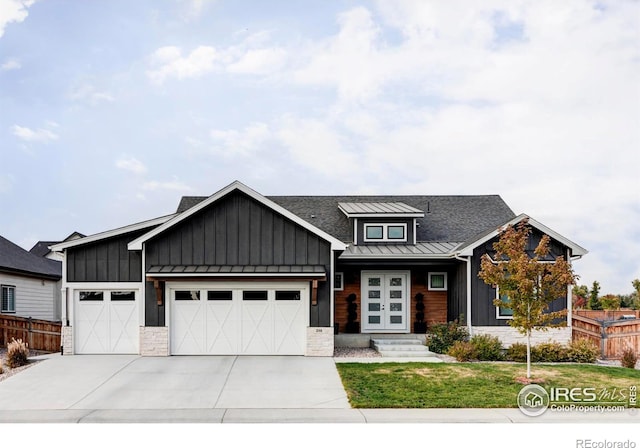 view of front of property with a garage, board and batten siding, a standing seam roof, and fence